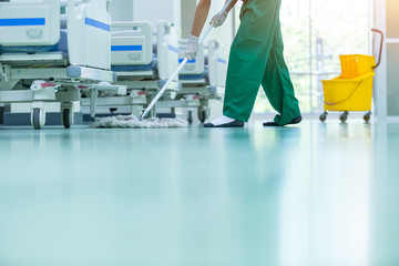 Cleaner using mops, cleaner with mop and uniform cleaning hall floor, hospital cleaning floor with...