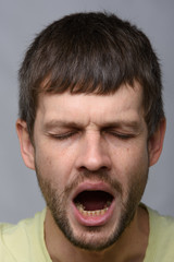 Fototapeta premium Close-up portrait of a yawning man of European appearance