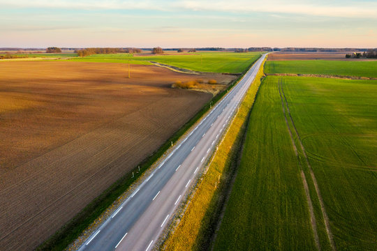 Aerial view of a highway passing through spring agricultural fields at sunset © smiltena