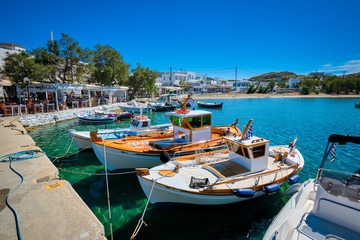 Fototapeta na wymiar Fishing boats in harbour fishing village of Pollonia with fishing boats moored to pier in sea. Pollonia town, Milos island, Greece