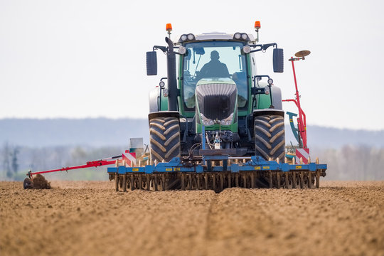 un tracteur avan&ccedil;ant dans les sillons trac&eacute;s pour semer des graines