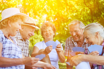 Gruppe Senioren beim Karten spielen im Sommer