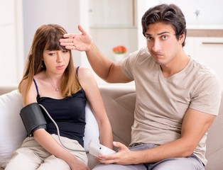 Fototapeta premium Husband checking wife's blood pressure