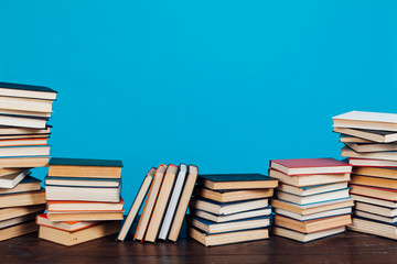 many stacks of educational books to teach in the library on a blue background