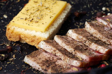 Closeup slices of breast and a cheese sandwich with spices.