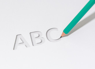 ABC drawn on a white sheet with a green pencil.