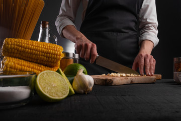 Chef slices fresh garlic to make fresh salad and Italian pasta. Culinary recipes, cookbooks, homemade recipes