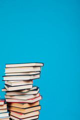 many stacks of educational books to teach in the library on a blue background