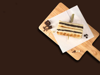 The delicious and delicious chocolate chip sandwiches are smeared on the toasted golden toast. They are arranged on baking paper and wooden texture cutting boards. They are presented with a brown back