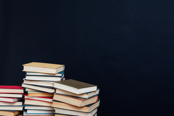 many stacks of educational books to teach in the library on a black background