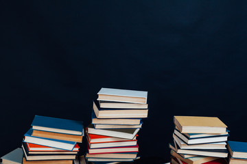many stacks of educational books to teach in the library on a black background