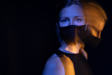 Beautiful sad eyes looking to the camera asking. Black mask. Black background. long exposure creative artistic photo series. respiratory breathing polluted air. epidemic panic pandemic.  