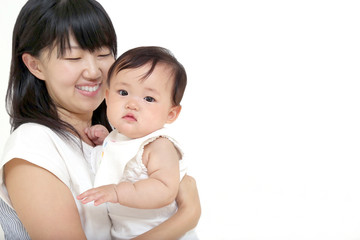 カメラ目線の赤ちゃんを抱く笑顔のお母さん。育児、愛情イメージ