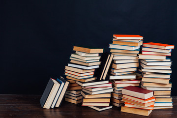 many stacks of educational books to teach in the library on a black background