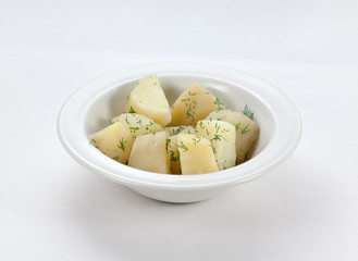 whole boiled potatoes in a plate on a white background