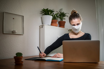 Woman with a mask in home office during Corona Virus time