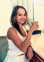 Young beautiful girl holding a cup of coffee in cafe. Outdoor portrait of young beautiful woman posing while traveling holiday vocation. Girl with coffee. Female traveler, travel vacation fun summer.