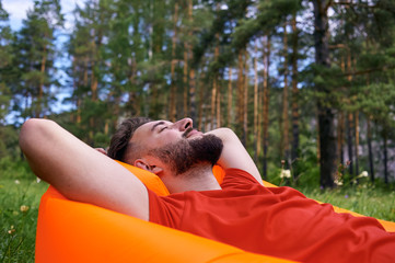 Enjoying life. A young man lies in a bivouac in the forest., relaxation, vacations, lifestyle concept