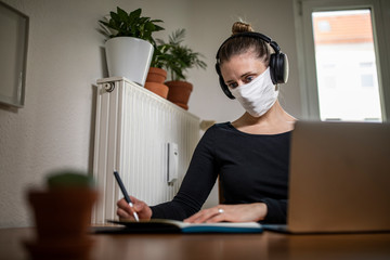 Woman with a mask in home office during Corona Virus time