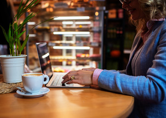 Business woman working on laptop while sitting in cafe