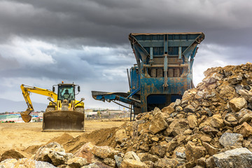 Excavator collecting stone in an open-cast mine
