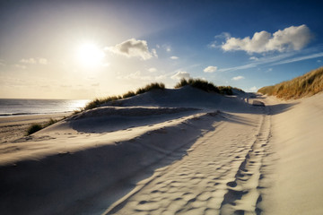 walking between sand dunes in sunshine