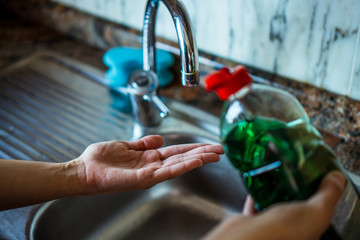 Woman washing her hands with soap in a hygienic way in her home sink. Kitchen