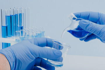 scientific laboratory equipment. hands of a scientific researcher in blue gloves