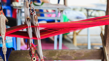 Tribal women are weaving with hand-made loom with wood, an ancient weaving machine inherited to ancestors and weaving is mostly for family use only.