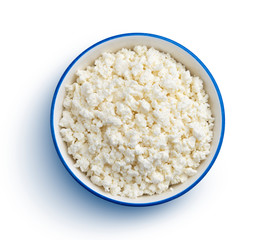 Cottage cheese in blue bowl isolated on white background, top view