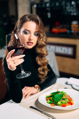 Young beautiful woman drinking wine in a restaurant.