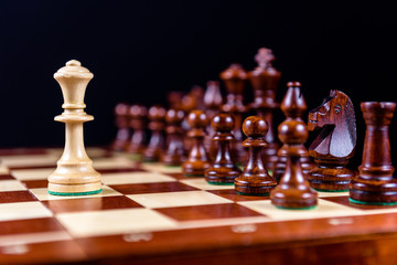 white chess Queen against black pieces