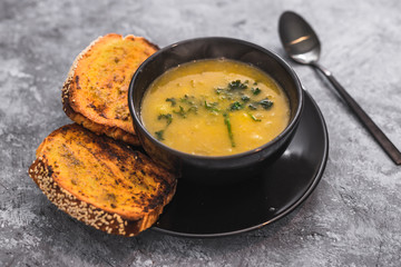 plant-based food, vegan cauliflower corn and onion soup with parsley topping and a side of garlic bread