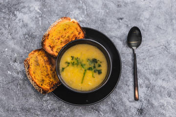 plant-based food, vegan cauliflower corn and onion soup with parsley topping and a side of garlic bread