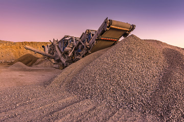 Excavator collecting stone in an open-cast mine - obrazy, fototapety, plakaty