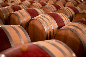 Wine barrels stacked in the old cellar of the winery. (Selective focus)