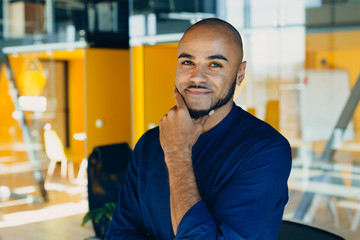 Happy african american businessman entrepreneur startup owner stand in modern office looking at camera, smiling young black designer creative  person posing in work space