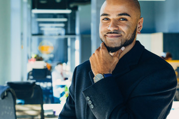 Happy african american businessman or or creative man with tablet in hands in modern free office, coworking