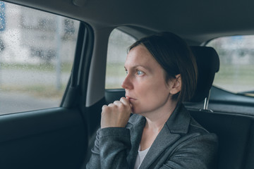 Fototapeta na wymiar Worried businesswoman sitting at car back seat