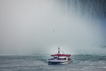 Detail of tourist boat in the waterfall on the Canadian side at sunset Concept of nature and travel Niagara Falls, Canada United States of America