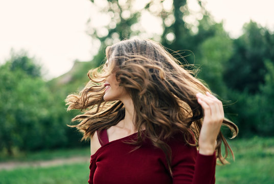 Young Happy Woman With Fluttering Hair Have Fun Outdoors On Green Summer Nature Background