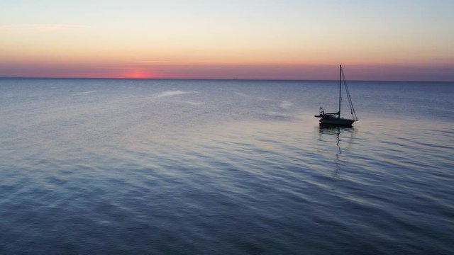 Drone passing a lonely, small sailboat at sea, drone stock footage by DroneRune