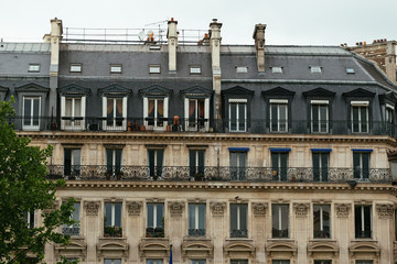 Typical old Paris architecture, facades of residential buildings with roofs, chimneys and mansards, expensive real estate concept. City residents self isolation, european lifestyle