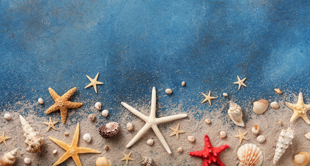 Seashell, starfish and beach sand on blue background. Summer holiday concept. Top view and flat lay. - Powered by Adobe