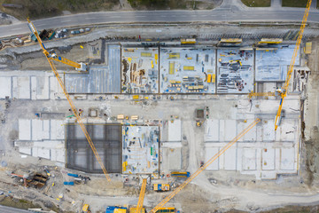 aerial bird eye top view to huge construction site with cranes diggers and concrete base plate
