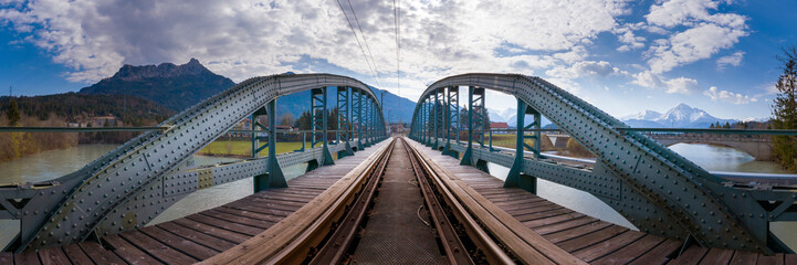 Fototapeta na wymiar panorama view to old metallic railway bridge with risty rails over rural river lech in austra