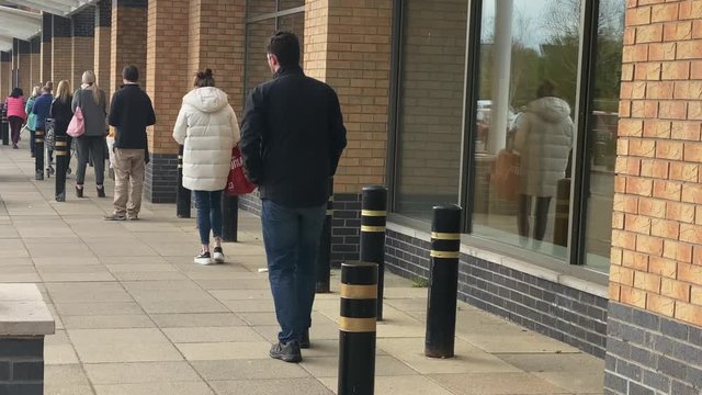 People social distancing outside supermarket