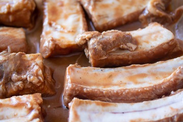 Raw marinaded juicy pork ribs ready for cooking. Meat processing picture. Food photography close up background
