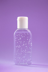 A bottle of hand sanitizer gel. Hand hygiene as coronavirus protection. Antivirus and antibacterial product. Purple liquid with white round granules