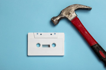 white blank audio cassette and hammer, destructive music concept